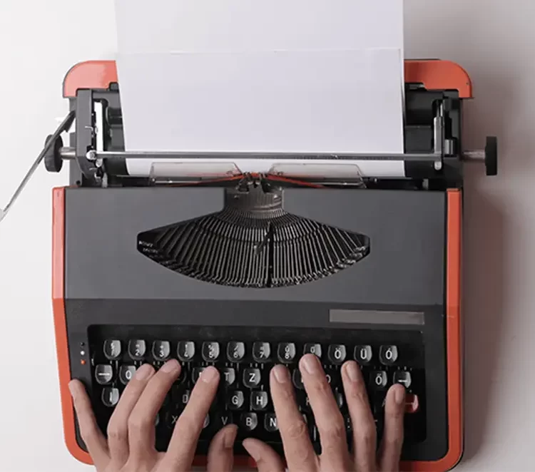 Brand Story Blog hand using old fashioned typewriter